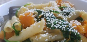 Pasta with spinach, pumpkin, and sesame seeds.